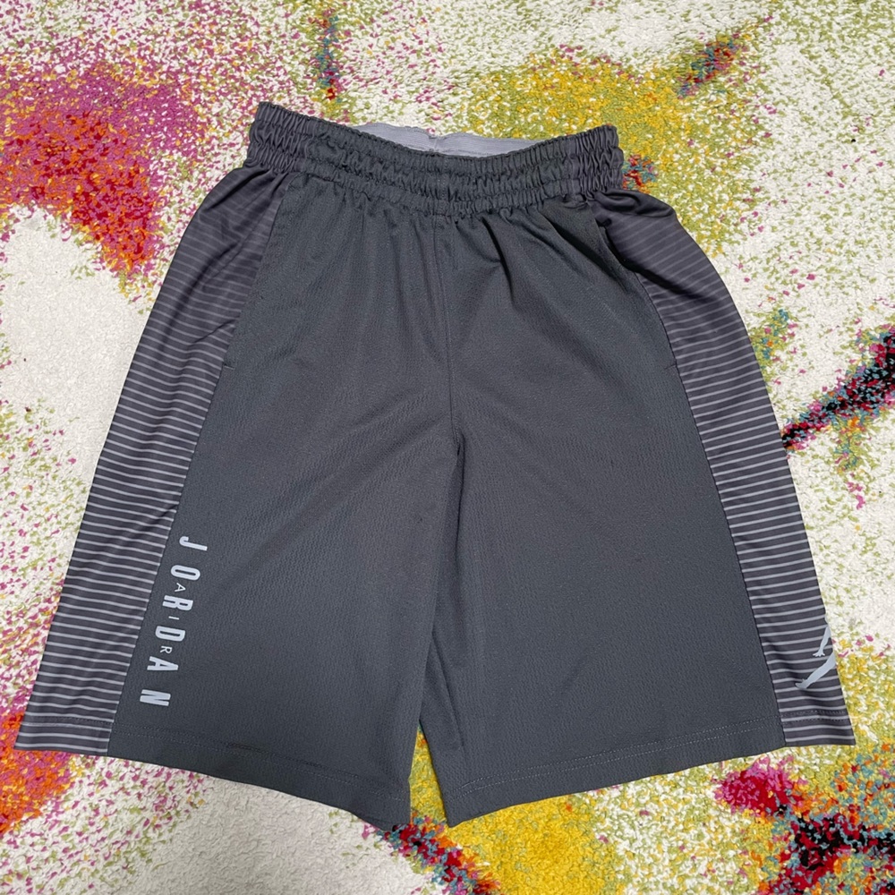 These are grey Jordan Dri-FIT basketball shorts with white striped side panels.
